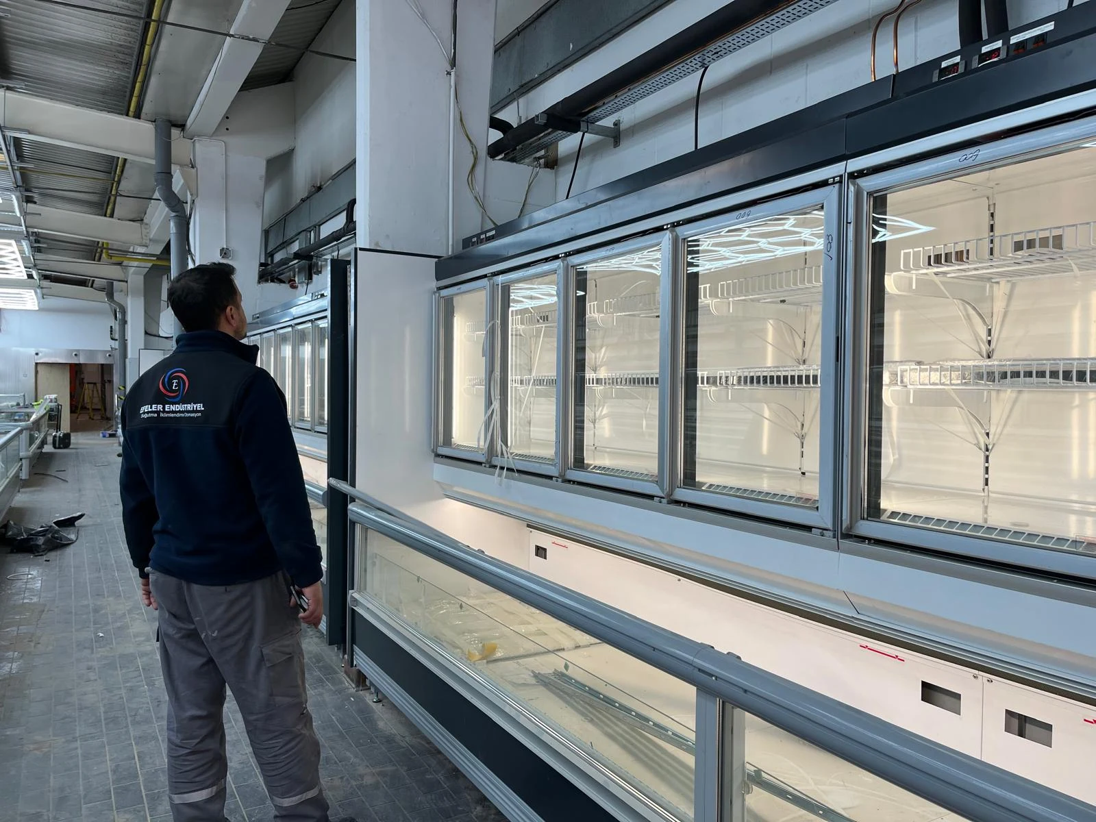 Soğutmalı teşhir sistemi üzerinde çalışan Efeler teknik personeli